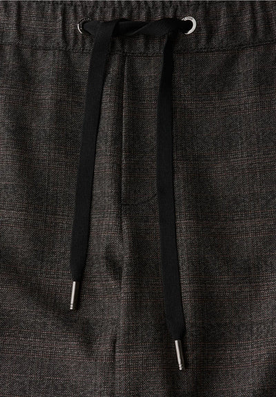 Dark gray pants with a drawstring on a matching fabric background