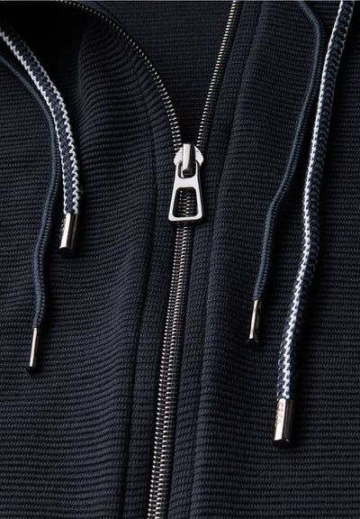 Close-up of a black textured hoodie with a zipper