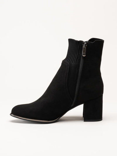 Black sock boot with a zipper on a white background