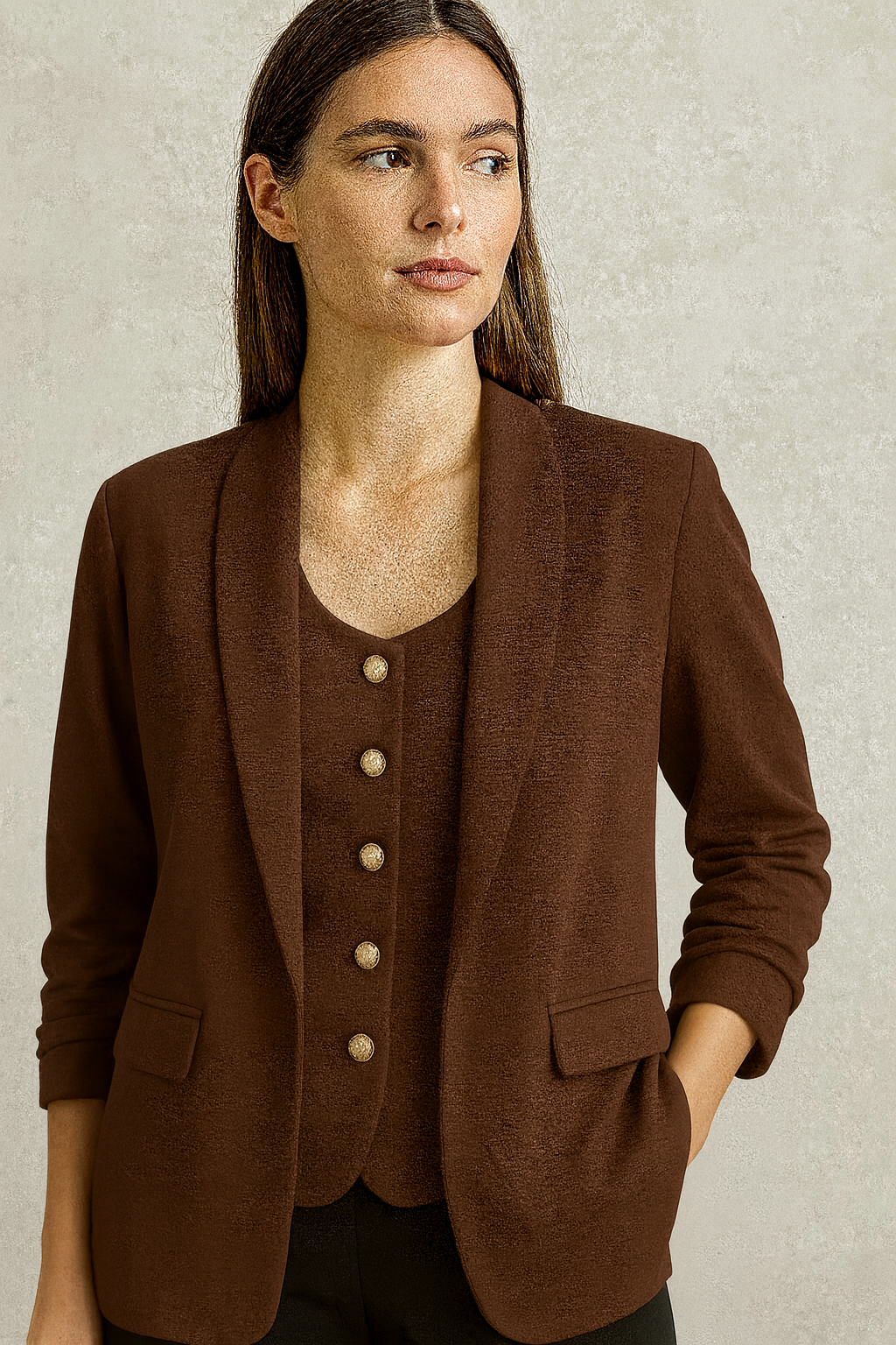 Woman wearing a brown blazer with a neutral background