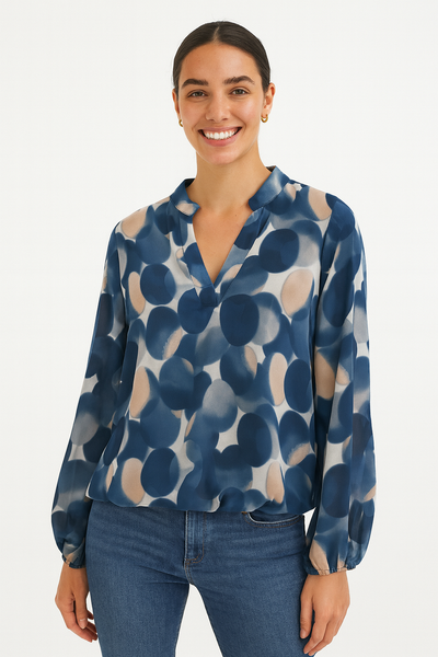 Woman wearing a blue patterned blouse and jeans on a white background