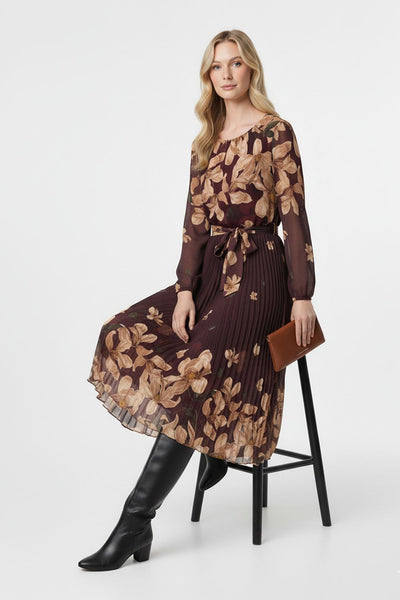 Woman wearing a brown floral dress with black boots on a white background