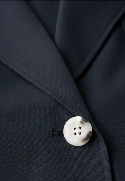 Close-up of a button on a dark blue suit jacket