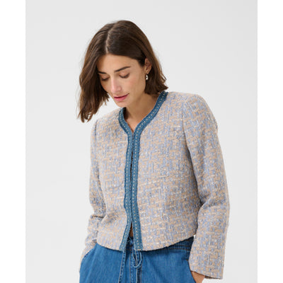 Woman wearing a patterned cardigan with a white background