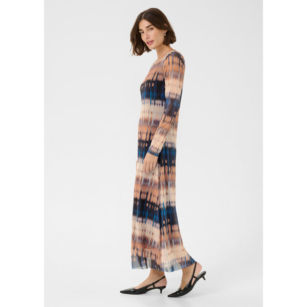 Woman wearing a long, patterned dress on a white background