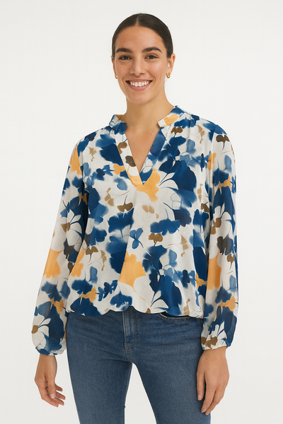 Woman wearing a floral blouse with blue jeans on a white background