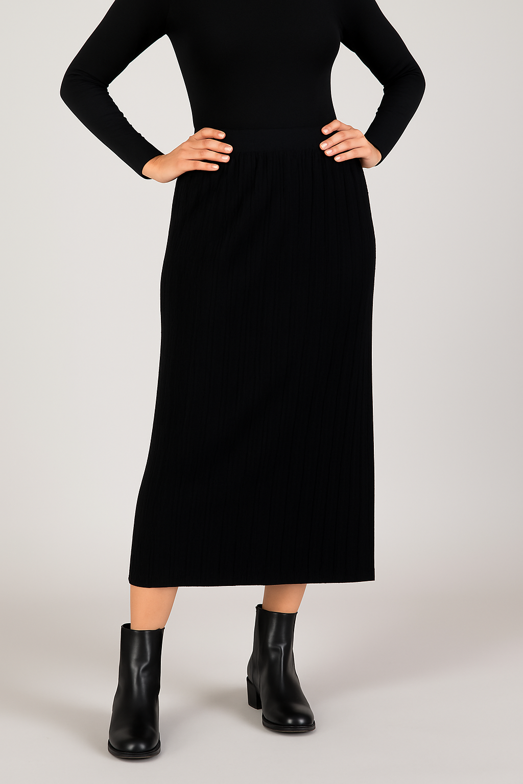 Person wearing a black dress with black boots on a light gray background