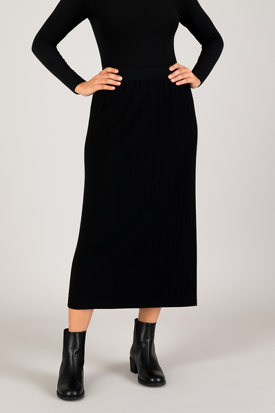 Person wearing a black dress with black boots on a light gray background