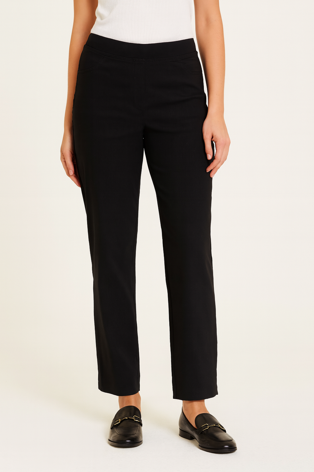 Person wearing black pants and black shoes on a white background