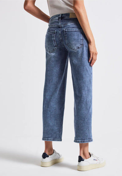 Person wearing blue jeans on a white background
