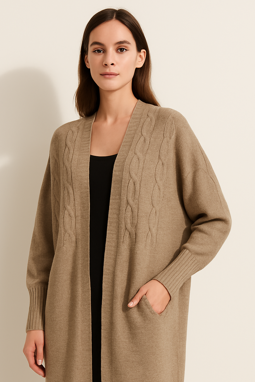 Woman wearing a long beige cardigan against a plain background