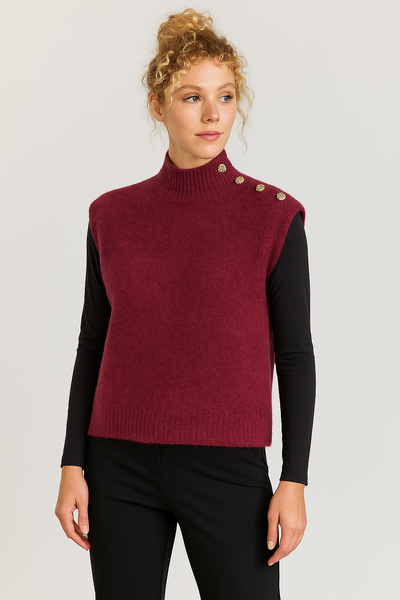 Woman wearing a burgundy sweater vest with button details on a plain background