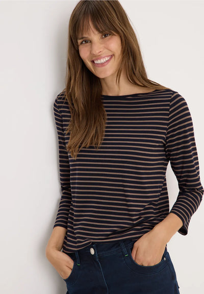 Woman wearing a striped long-sleeve shirt against a plain background