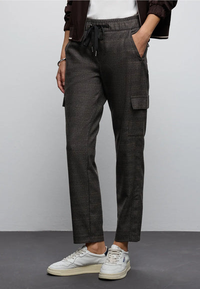 Person wearing dark gray cargo pants with a plain background
