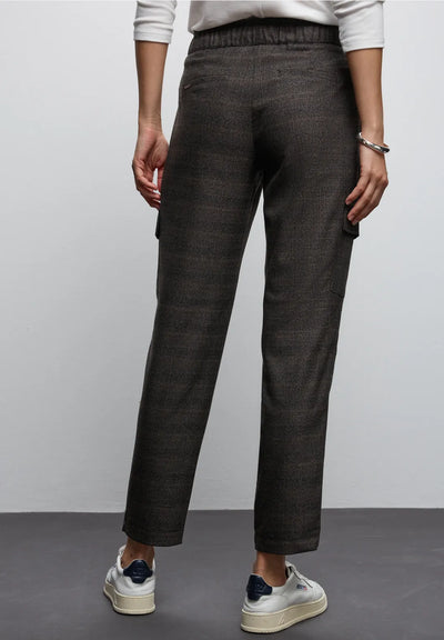 Person wearing dark gray pants with a plain background