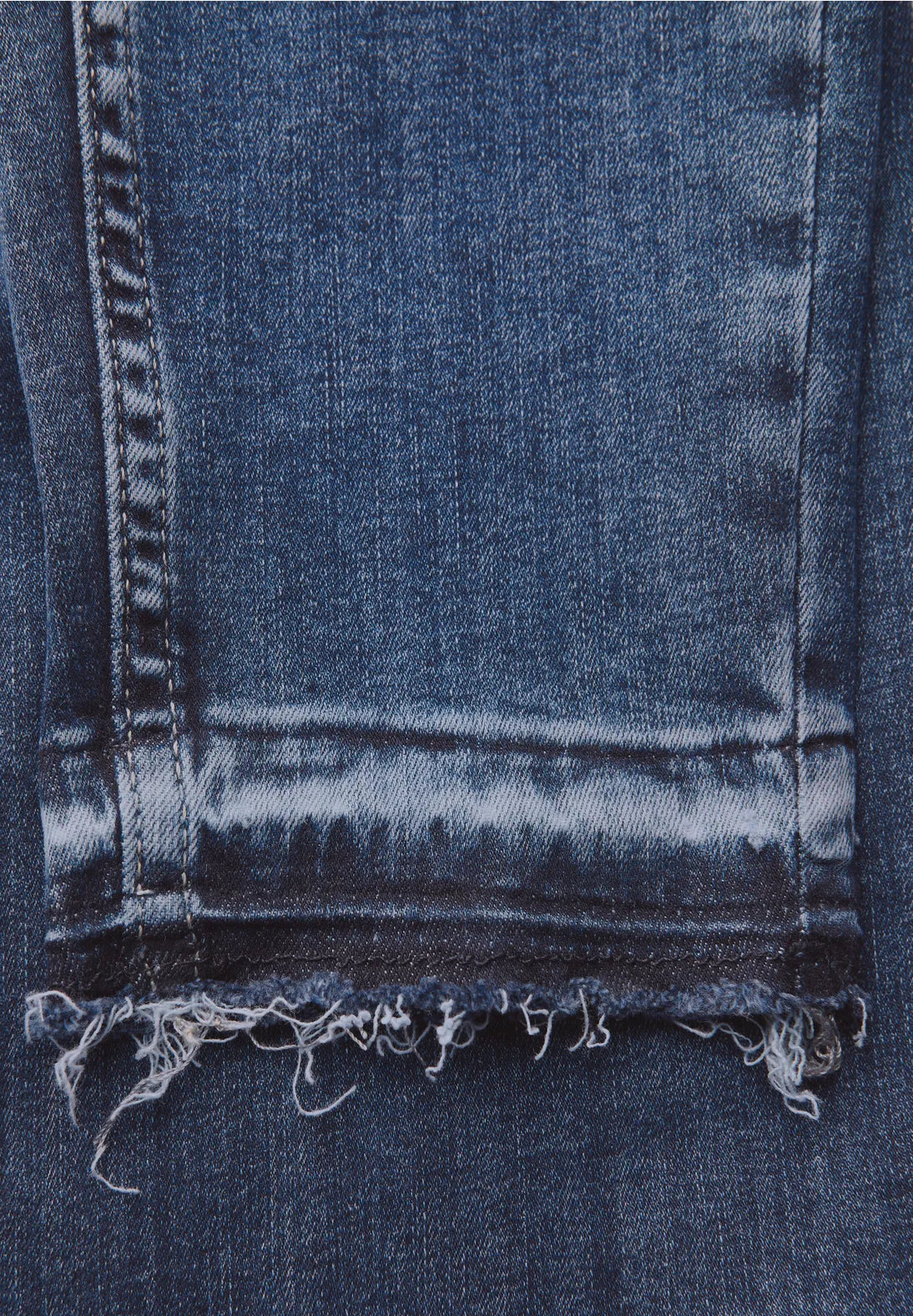 Close-up of a blue denim fabric with frayed edge