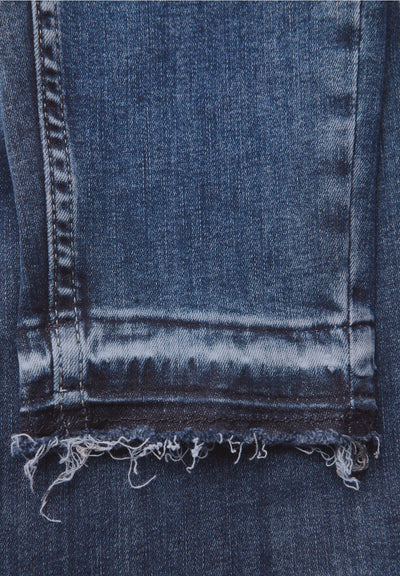 Close-up of a blue denim fabric with frayed edge