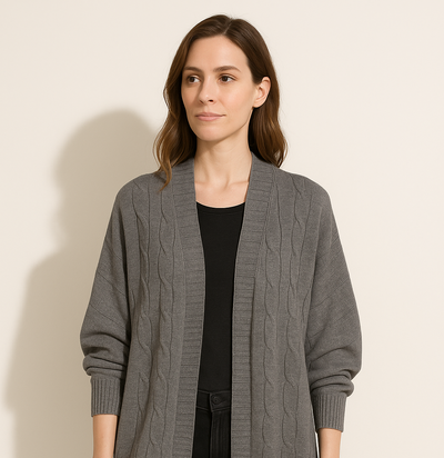 Woman wearing a gray cardigan over a black top and pants on a beige background