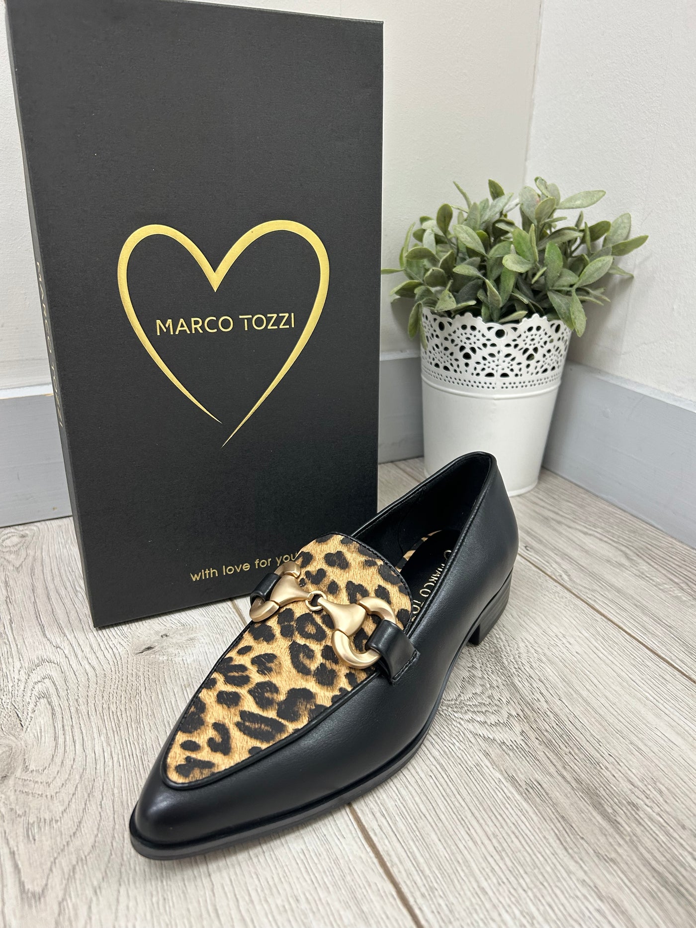 Black loafer with leopard print pattern on a Marco Tozzi branded box.