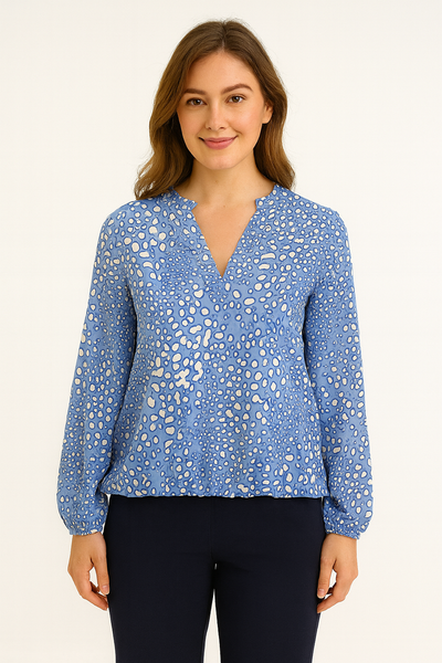 Woman wearing a blue patterned blouse against a white background