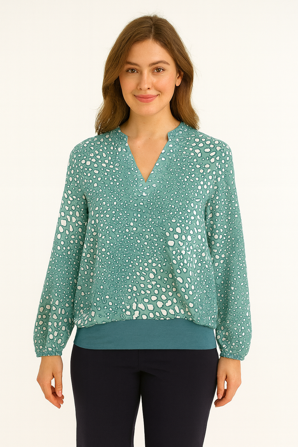 Woman wearing a teal blouse with a subtle pattern on a white background