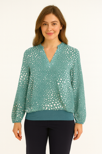 Woman wearing a teal blouse with a subtle pattern on a white background