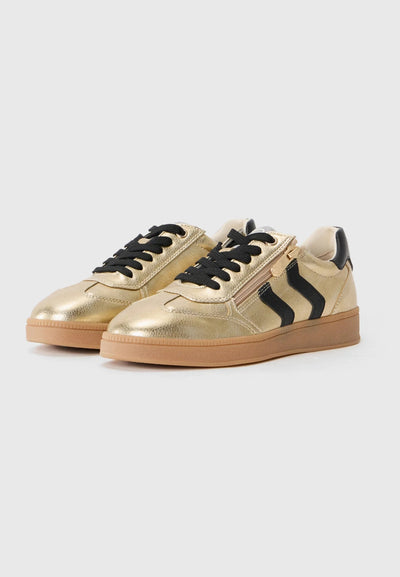 Gold sneakers with black laces on a white background