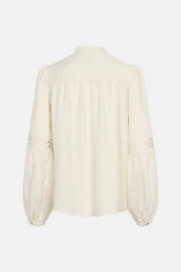 Cream-colored blouse with intricate detailing on a white background