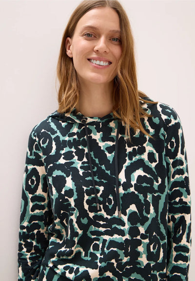 Woman wearing a patterned hoodie against a plain background
