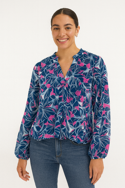 Woman wearing a blue floral blouse with pink flowers on a white background