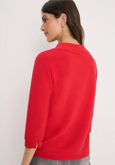 Woman wearing a red sweater against a white background