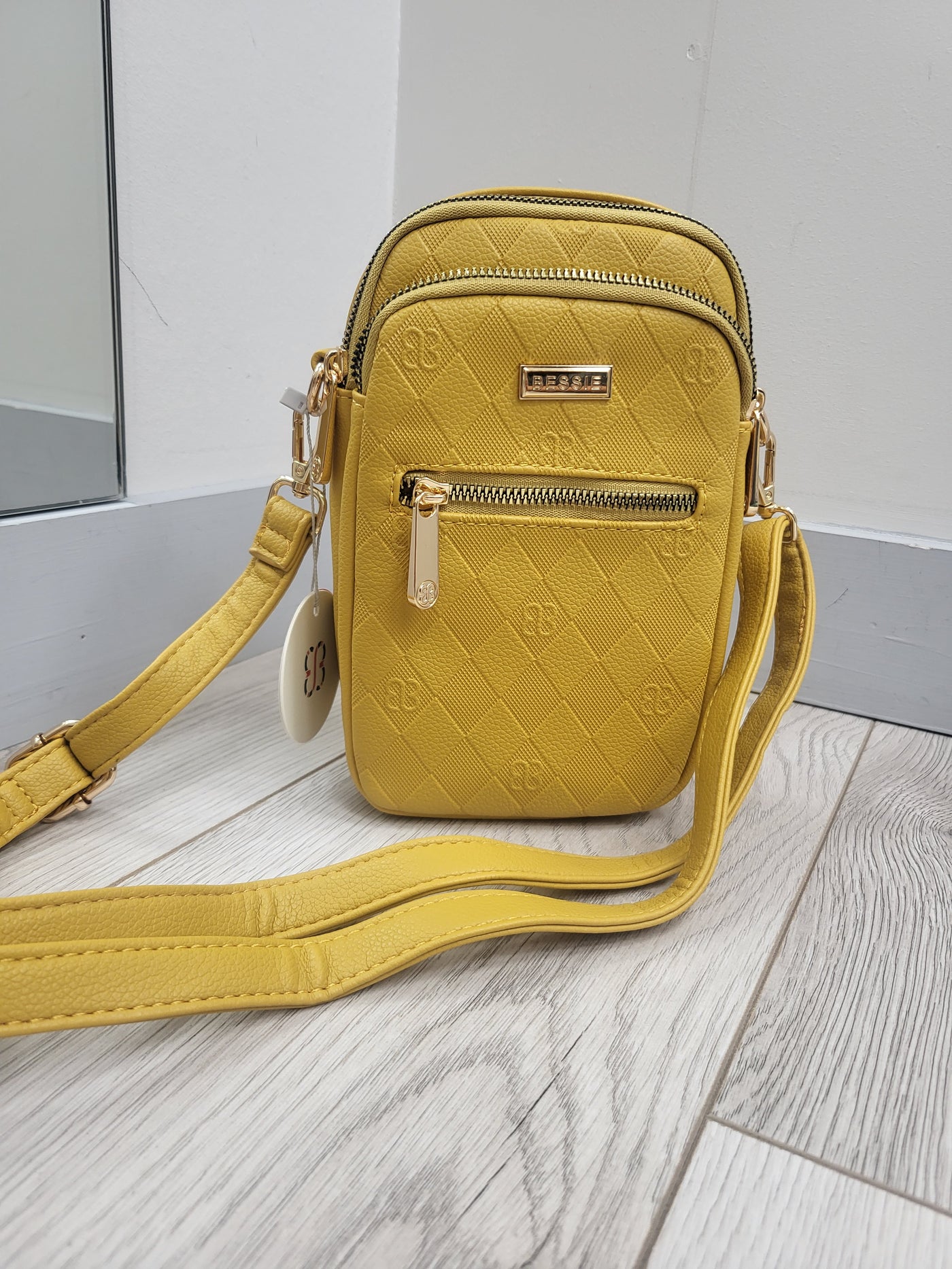 Yellow quilted handbag with a strap on a light wooden floor