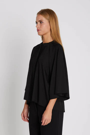 Woman wearing a black outfit on a plain background