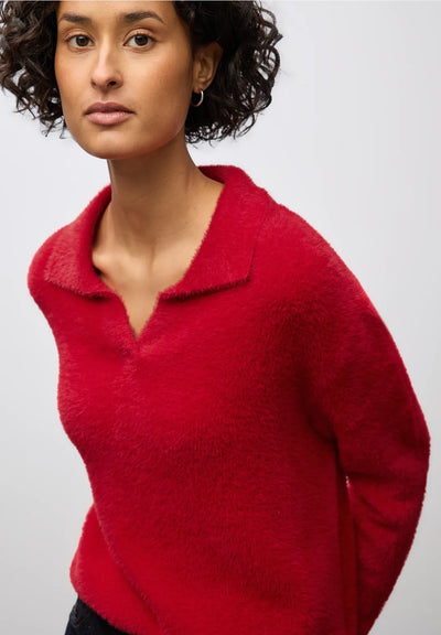 Woman wearing a red sweater against a plain background