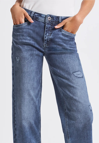 Blue jeans worn by a person on a white background