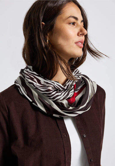 Woman wearing a zebra print scarf with a plain background