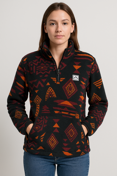 Woman wearing a black fleece pullover with red and orange geometric pattern on a plain background