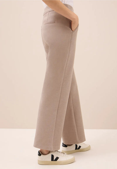 Beige wide-leg pants worn by a person on a plain background